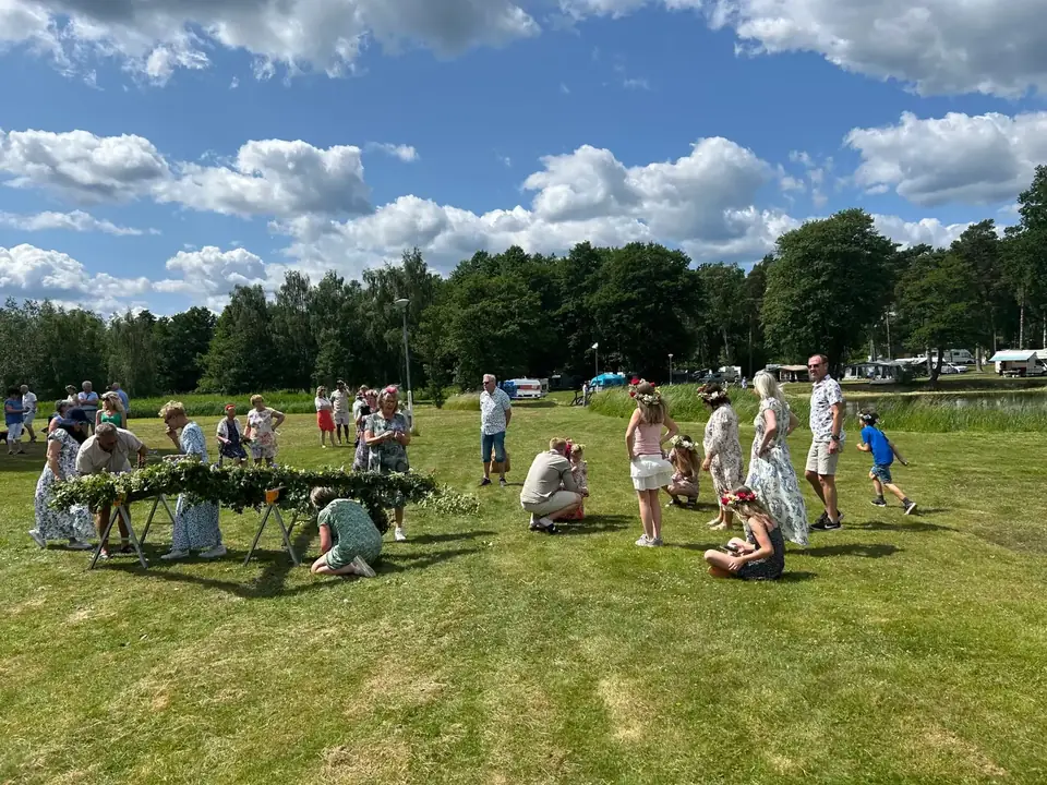 Barn och vuxna leker på gräset under midsommarfirande